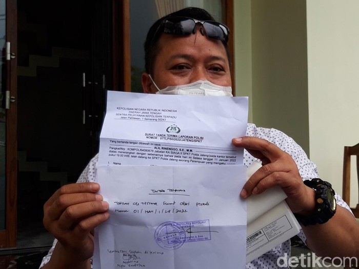 Kuasa hukum R, Hery Hartono, menunjukkan surat tanda penerimaan laporan.