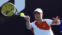 Djokovic seharusnya bertanding melawan sesama petenis Serbia, Miomir Kecmanovic, pada babak pertama. Namun, setelah dipastikan tak bisa ikut serta, Djokovic digantikan oleh petenis lucky loser alias salah satu petenis yang kalah dalam babak kualifikasi, tetapi masuk babak utama karena menggantikan atlet yang mundur. (AP/Tertius Pickard)