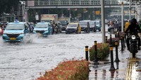 Pemotor melintasi jalur pedestrian untuk menghindari genangan air.