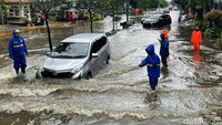 Mobil yang melintas harus menurunkan kecepatan saat menerobos genangan.