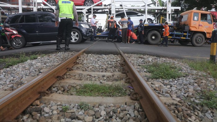 TRUK TERSANGKUT PERLINTASAN KERETA API Truk pengangkut mobil tersangkut pada perlintasan kereta api di Kelurahan Balowerti, Kota Kediri, Jawa Timur, Selasa (18/1/2022). Truk pengirim mobil baru dari Jakarta ke Tulungagung tersebut tersangkut tepat di atas rel selama 1,5 jam yang mengakibatkan perjalanan kereta api Kartanegara teganggu. ANTARA FOTO/Prasetia Fauzani/foc.