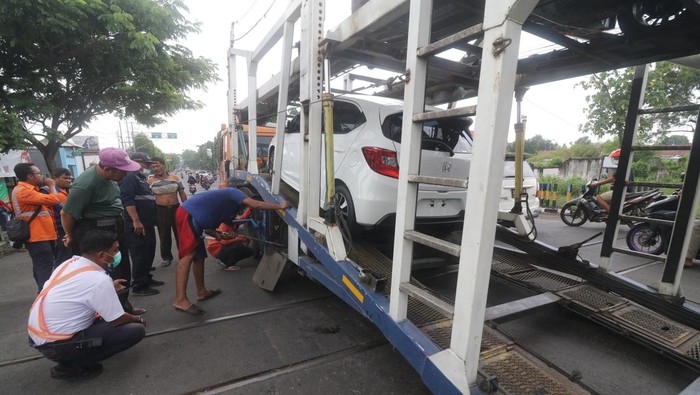 TRUK TERSANGKUT PERLINTASAN KERETA API Truk pengangkut mobil tersangkut pada perlintasan kereta api di Kelurahan Balowerti, Kota Kediri, Jawa Timur, Selasa (18/1/2022). Truk pengirim mobil baru dari Jakarta ke Tulungagung tersebut tersangkut tepat di atas rel selama 1,5 jam yang mengakibatkan perjalanan kereta api Kartanegara teganggu. ANTARA FOTO/Prasetia Fauzani/foc.