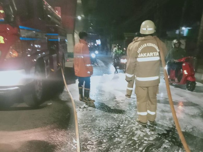 Tumpahan minyak di Jalan Ciledug Raya, Jaksel menyebabkan sejumlah pengendara sepeda motor terjatuh. Petugas damkar membersihkan tumpahan minyak tersebut. (dok Sudin Gulkarmat Jaksel)