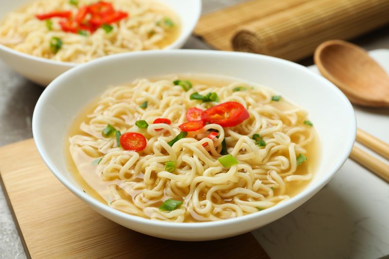 Konsep makanan lezat dengan semangkuk mie dengan latar belakang abu-abu