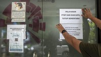Petugas memasang informasi masyarakat di Kantor Kelurahan Gondangdia, Jakarta, Rabu (19/1/2022).