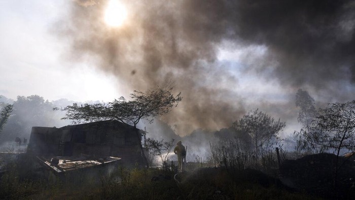 Cuaca Panas Ekstrem Picu Kebakaran Lahan di Paraguay A volunteer firefighter hoses down a hut to prevent it from burning during a brush fire at the Banco San Miguel neighborhood of Asuncion, Paraguay, Tuesday, Jan. 18, 2022. Unusually dry weather is provoking fires on open fields, private ranches and public lands around the city. (AP Photo/Jorge Saenz)