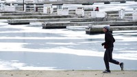 Seorang pria berlari di sepanjang area yang tertutup salju di Pantai Montrose di Chicago. Pada musim dingin, cuaca bisa di bawah nol derajat. Namun pada musim panas, suhu sangat gerah dapat mencapai 38 derajat Celcius.