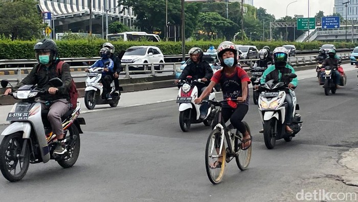 Ada yang unik dengan pesepeda yang melintas di Jalan Gatot Subroto, Jakarta, Rabu (19/1/2022). Dia gowes sepedanya dengan menggunakan helm motor.
