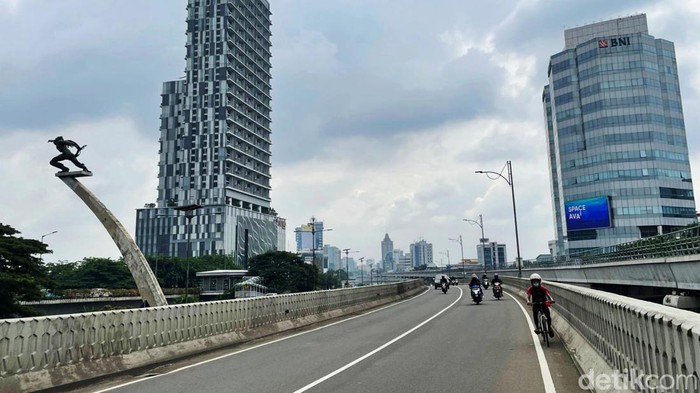 Gaya Pede Pesepeda Gowes Pakai Helm Motor Ada yang unik dengan pesepeda yang melintas di Jalan Gatot Subroto, Jakarta, Rabu (19/1/2022). Dia gowes sepedanya dengan menggunakan helm motor.