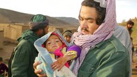 Seorang warga menunjukan bayi yang selamat dari gempa namun harus kehilangan tempat tinggal. Banyak rumah rata dengan tanah akibat gempa.