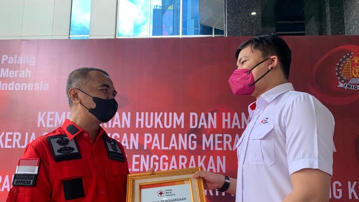 Ketua Bidang Kerjasama dan Kemitraan PMI DKI Jakarta, Arya Sandhiyudha berikan piagam kepada Direktur Kerjasama Keimigrasian, Agus Wijaya atas kerjasama kegiatan donor darah.