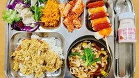 Murid di salah satu sekolah di Korea Selatan dapat menu makan siang yang lengkap dan enak. Terlihat ada nasi plus pork cutlet, udon, salad, kimchi, tteok (kue beras), sampai susu strawberry!