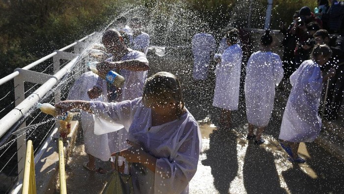 Melihat Ritual Pembaptisan di Sungai Yordan A Orthodox Christian pilgrim immerses himself in the Jordan River during a baptism ceremony as part of the Orthodox Feast of the Epiphany at Qasr el Yahud, near the West Bank town of Jericho, Tuesday, Jan. 18, 2022. The site is traditionally believed by many to be the place where Jesus was baptized. (AP Photo/Mahmoud Illean)