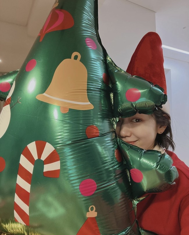Sang ibu hamil kembali menyapa penggemar saat perayaan Natal. Park Shin Hye mengunggah fotonya mengenakan kostum santa claus sambil memeluk balon hijau berbentuk pohon natal. “Happy Christmas❣️” tulisnya sebagai caption. Foto: dok Instagram ssinz7