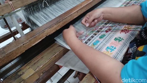 Pekerja tengah membuat kain tenun dengan menggunakan alat tenun bukan mesin (ATBM)