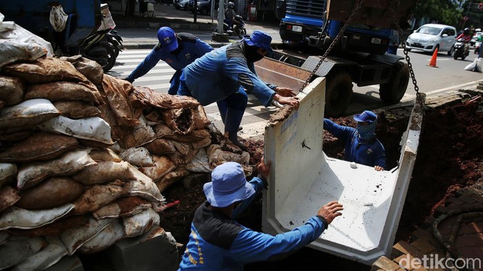 Pasukan biru memasangkan box culvert kedalam gorong-gorong di Jalan HOS Cokroaminoto Menteng, Jakarta Pusat, Rabu (19/1/2021). Pembuatan gorong-gorong ini sebagai salah satu sistem drainase untuk mengatasi genangan maupun banjir dikawasan tersebut.