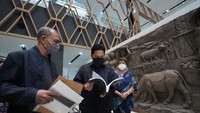 Menteri BUMN Erick Thohir tampak serius membaca buku, dengan latar belakang dinding dengan berbagai ornamen.Foto: Dok. Kementerian BUMN/Dhika Septa Permana
