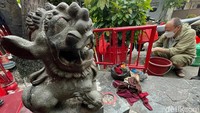 Warga membersihkan bagian pagar yang berwarna merah.