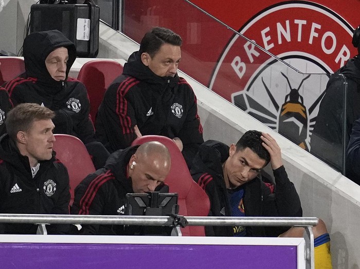 Manchester United's Cristiano Ronaldo, right, sits watching the game after being substituted during an English Premier League soccer match between Brentford and Manchester United at the Brentford Community Stadium in London, Wednesday, Jan. 19, 2022. (AP Photo/Matt Dunham)