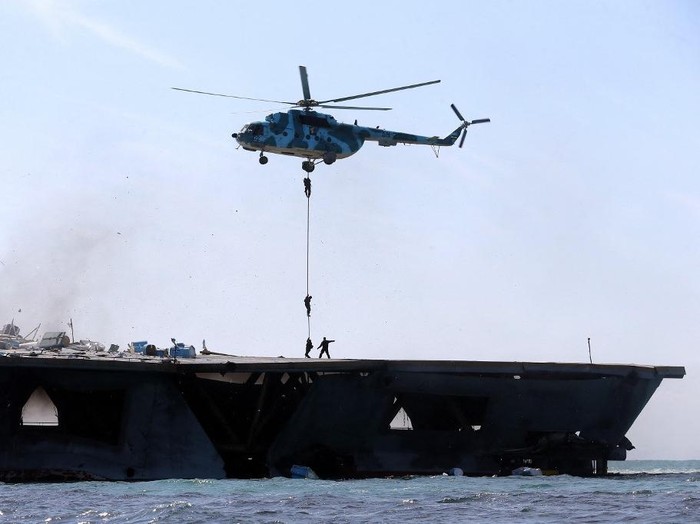 Irans elite Revolutionary Guard troops rappel down a helicopter on a naval vessel during a military drill in the Strait of Hormuz in southern Iran on February 25, 2015. Irans Revolutionary Guards began naval exercises in the Strait of Hormuz, just a few hundred kilometres away from western vessels engaged in the fight against the Islamic State group. AFP PHOTO / FARS NEWS / HAMED JAFARNEJAD (Photo by Hamed Jafarnejad / FARS NEWS / AFP)