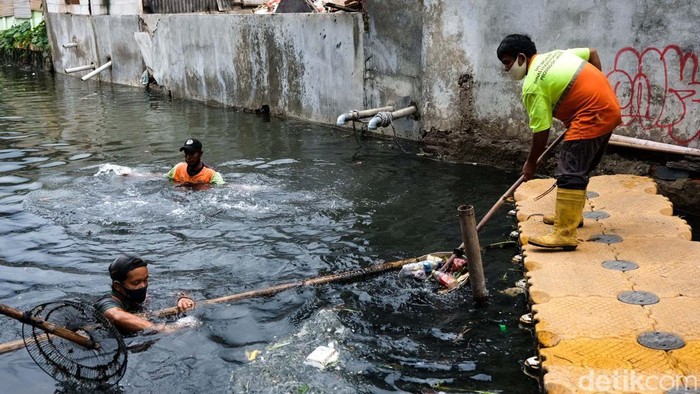 Imbas Banjir Tegal Alur, Sampah Berserakan di Sungai Banjir di Kelurahan Tegal Alur, Jakarta Barat, membuat sampah plastik berserakan di sungai. Sampah tersebut diangkut petugas UPK Badan Air.