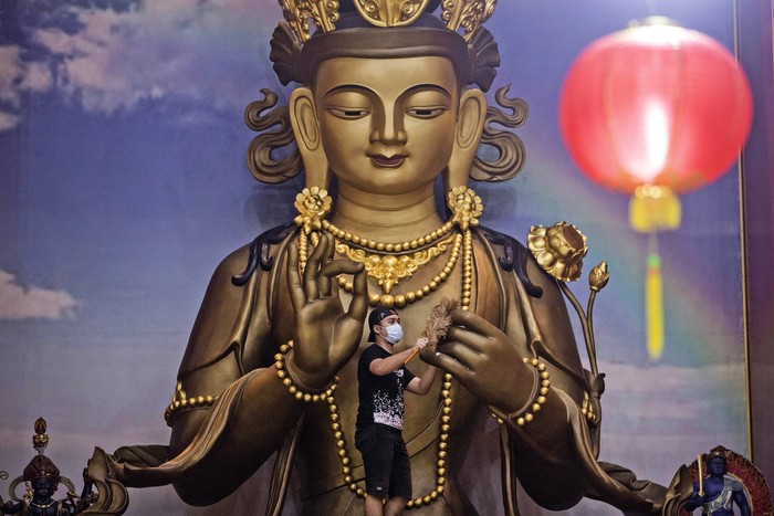 A worker cleans a Buddha statue in preparation for the Lunar New Year celebrations at Satya Buddha Temple in Medan, North Sumatra, Indonesia, Wednesday, Jan. 19, 2022. Chinese people around the world will be celebrating the beginning of the Year of Tiger on Feb. 1. (AP Photo/Binsar Bakkara)
