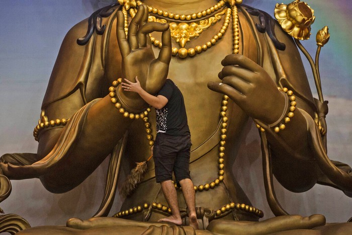 A worker cleans a Buddha statue in preparation for the Lunar New Year celebrations at Satya Buddha Temple in Medan, North Sumatra, Indonesia, Wednesday, Jan. 19, 2022. Chinese people around the world will be celebrating the beginning of the Year of Tiger on Feb. 1. (AP Photo/Binsar Bakkara)