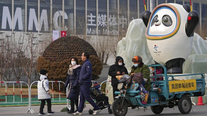 Olimpiade Musim Dingin Digelar Tertutup, Warga Beijing Kecewa A woman wearing a face mask to help protect from the coronavirus takes a selfie with her companion against a Beijing Winter Olympics Mascot and Olympic Tower in Beijing, Wednesday, Jan. 19, 2022. China has locked down parts of Beijing's Haidian district following the detection of three cases, just weeks before the capital is to host the Winter Olympic Games. (AP Photo/Andy Wong)