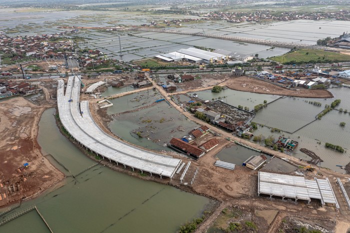 Foto udara proyek pembangunan Jalan Tol Semarang - Demak seksi II di Kecamatan Sayung, Kabupaten Demak, Jawa Tengah, Rabu (19/1/2022). Menurut data yang dihimpun PT PP selaku kontraktor pelaksana proyek jalan tol tersebut dengan skema Join Operation bersama PT Wika, progres pembangunan jalan Tol Semarang-Demak seksi II (Sayung-Demak) sepanjang 16,31 kilometer per 17 Januari 2022 telah mencapai sekitar 64 persen, dan ditargetkan selesai pada Oktober 2022 mendatang. ANTARA FOTO/Aji Styawan/hp.