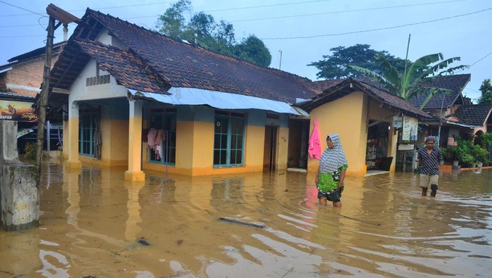 Sungai Meluap, Ratusan Rumah di Kudus Kebanjiran Dua anak melintasi jalan yang tergenang banjir di Desa Golantepus, Mejobo, Kudus, Jawa Tengah, Kamis (20/1/2022). Akibat intensitas hujan yang tinggi serta meluapnya Sungai Mrisen menyebabkan ratusan rumah dan jalan utama di desa itu terendam banjir. ANTARA FOTO/Yusuf Nugroho/tom.