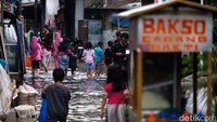 Warga beraktivitas di tengah banjir di RT 01, RW 02, Kelurahan Tegal Alur, Jakarta Barat.