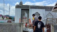 Terlihat aparat kepolisian berada di sela-sela puing atap masjid yang dibongkar (dokumen istimewa).