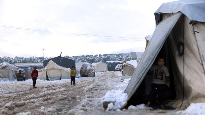 Warga di Lebanon Bertahan Hidup Kala Dihantam Badai Salju Displaced Syrian children walk in the snow at a refugee camp, in Afrin, north of Aleppo, Syria, Wednesday, Jan. 19, 2022. A snowstorm in the Middle East has left many Lebanese and Syrians scrambling to find ways to survive. Some are burning old clothes, plastic and other hazardous materials to keep warm as temperatures plummet and poverty soars. (AP Photo/Ghaith Alsayed)
