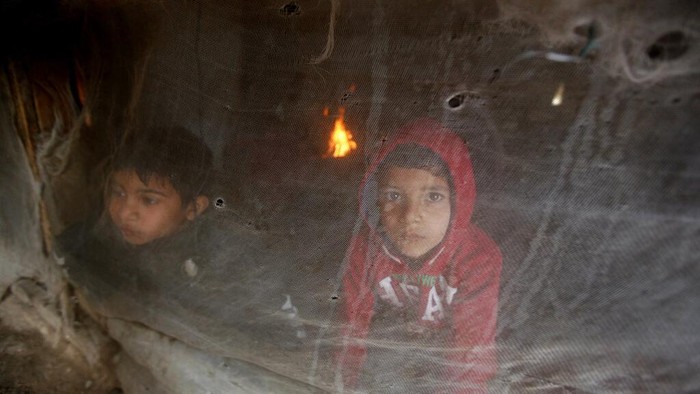 Warga di Lebanon Bertahan Hidup Kala Dihantam Badai Salju Displaced Syrian boys look through their tent window as they try to stay warm at a refugee camp near the southern port city of Zahrani, Lebanon, Wednesday, Jan. 19, 2022. A snowstorm in the Middle East has left many Lebanese and Syrians scrambling to find ways to survive. Some are burning old clothes, plastic and other hazardous materials to keep warm as temperatures plummet and poverty soars. (AP Photo/Mohammed Zaatari)