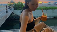 Segelas minuman dingin sedang asyik dinikmati Lala. Ia memilih minum sambil santai memandang sunset di pinggir pantai. Seru! Foto: instagram @lalachoo2005