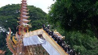 Umat Hindu menurunkan peti jenazah Raja Pemecutan XI Anak Agung Ngurah Manik Parasara saat upacara ngaben di Denpasar, Bali, Jumat (21/1/2022).  