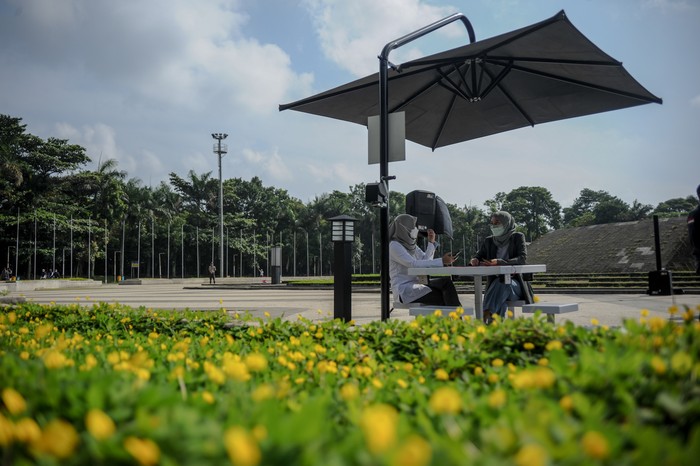 Warga berada di saung panel surya usai diresmikan di Taman Tegallega, Bandung, Jawa Barat, Rabu (19/1/2022). Pemerintah Kota Bandung bekerja sama dengan PT Len Industries (Persero) memasang 10 unit saung bertenaga surya di sejumlah taman di Kota Bandung yang dapat dimanfaatkan oleh masyarakat untuk mengisi daya perangkat elektronik dan lampu penerangan sekaligus upaya edukasi pemanfaatan energi terbarukan. ANTARA FOTO/Raisan Al Farisi/rwa.