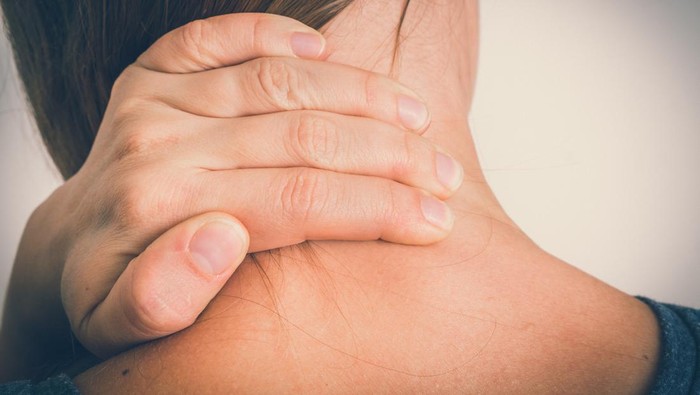 nyeri leher Woman with muscle injury having pain in her neck - body pain concept