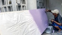 Pekerja menyelesaikan proses akhir furniture custom.