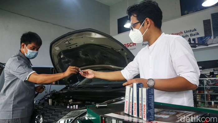 Seorang mekanik tengah melakukan pergantian busi di Alecon Racing Shop, Jakarta, Sabtu (22/1/2022). Dalam upaya mendukung pemerintah mengurangi pencemaran udara, Bosch akan memberikan fasilitas berupa 6.000 busi, yang akan dibagikan kepada 100 bengkel di wilayah JABODETABEK.