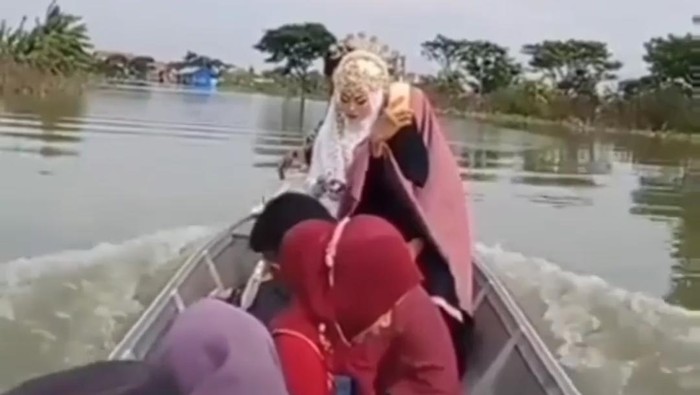 Video mempelai wanita mengarungi banjir beredar di media sosial. Pengantin itu naik perahu menuju tempat akad nikah, yakni KUA Kecamatan Turi.