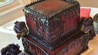 Tak ingin terlalu feminin, pasangan pengantin ini mencari jalan tengah untuk tema kue. Ada jaring spiderman dan warna gelap tetapi kelopak bunga dihadirkan demi memenuhi keinginan pengantin perempuan. Foto: Brightside