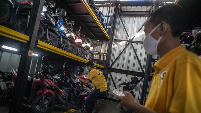 Pekerja mengakses aplikasi saat akan menurunkan sepeda motor di Soul Parking, Kebon Kacang, Jakarta, Jumat (21/1/2022). Tempat parkir vertikal tersebut menerapkan sistem teknologi Compact Motor Storage atau sistem rak bersusun dengan lift barang sehingga bisa menyimpan lebih banyak motor di atas lahan sempit dan menjadi salah satu solusi untuk penataan parkir khusus motor di wilayah Ibu Kota Jakarta. ANTARA FOTO/Aprillio Akbar/aww.