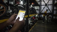 Pekerja mengakses aplikasi saat akan menurunkan sepeda motor di Soul Parking, Kebon Kacang, Jakarta. 