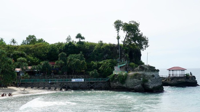 Sejumlah wisatawan mengunjungi Pantai Dato di Kabupaten Majene, Sulawesi Barat, Sabtu (22/1/2022). Pantai Dato merupakan tempat wisata yang ramai dikunjungi oleh wisatawan khususnya pada akhir pekan, dengan daya tarik pasir putih, terumbu karang dan tebing pegunungannya. ANTARA FOTO/Akbar Tado/foc.