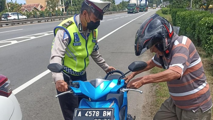 Petugas PJR Induk Serang mengamankan Kakek Suroso (72) yang masuk Tol Tangerang-Merak dengan sepeda motor.