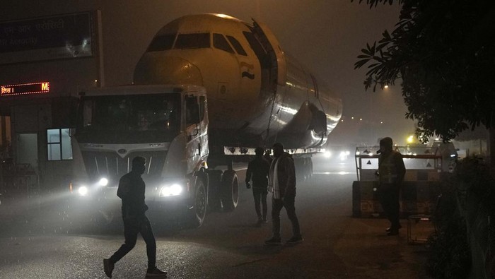 Wow! Pesawat Bekas Ini Dibeli untuk Jadi Restoran Workers clear overhead wires to make way for a scrapped Air India aircraft as it was being transported from the airport, in New Delhi, India, Saturday, Jan. 22, 2022. Scrapped planes purchased by private enterprises are used for commercial purpose like setting up restaurants, offices and other recreational activities. (AP Photo/Manish Swarup)