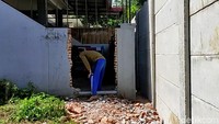 Subandi (50), salah satu warga terdampak terpaksa harus menjebol dinding teras sebelah kanan rumahnya. Dia membuat jalan yang sekiranya cukup untuk keluar masuk motornya.
