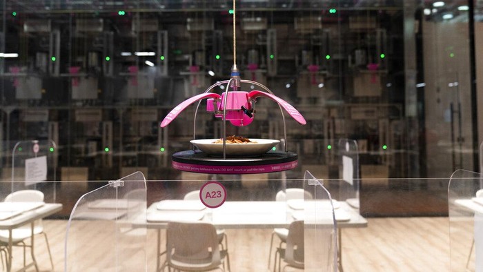 Food is delivered to a table robotically in the dining area of the main media center at the 2022 Winter Olympics, Monday, Jan. 24, 2022, in Beijing. (AP Photo/Jae C. Hong)