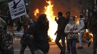 Demonstran juga tampak menyalakan api di tengah aksi unjuk rasa menolak vaksinasi dan aturan terkait COVID-19 di Belgia. AP Photo/Olivier Matthys. 